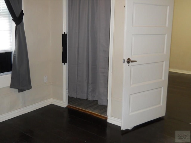 unfurnished bedroom with dark wood-type flooring