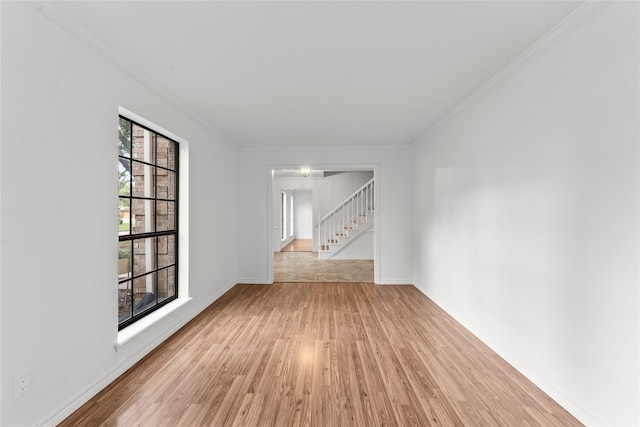 spare room with light hardwood / wood-style flooring and crown molding