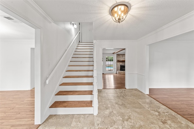 stairway featuring hardwood / wood-style flooring, a textured ceiling, and ornamental molding