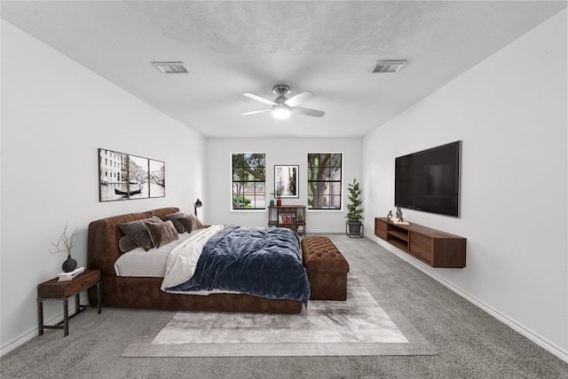 bedroom with a textured ceiling, carpet flooring, and ceiling fan