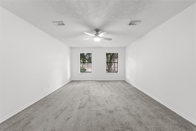 spare room featuring ceiling fan, carpet floors, and a textured ceiling