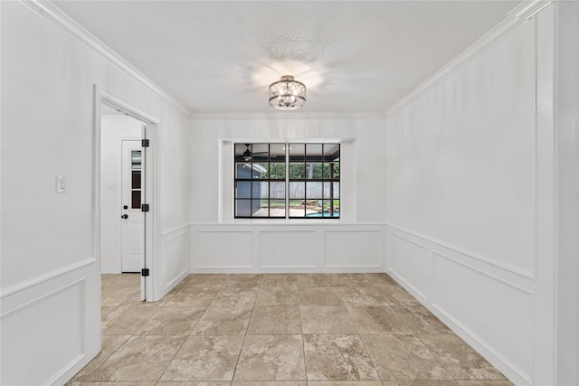 unfurnished dining area featuring a chandelier, a textured ceiling, and ornamental molding