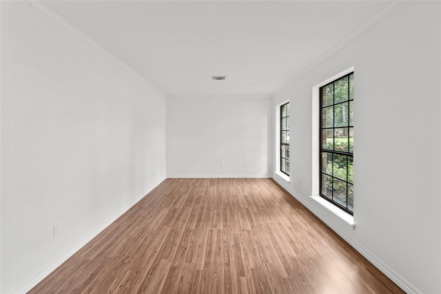 empty room featuring hardwood / wood-style flooring and ornamental molding