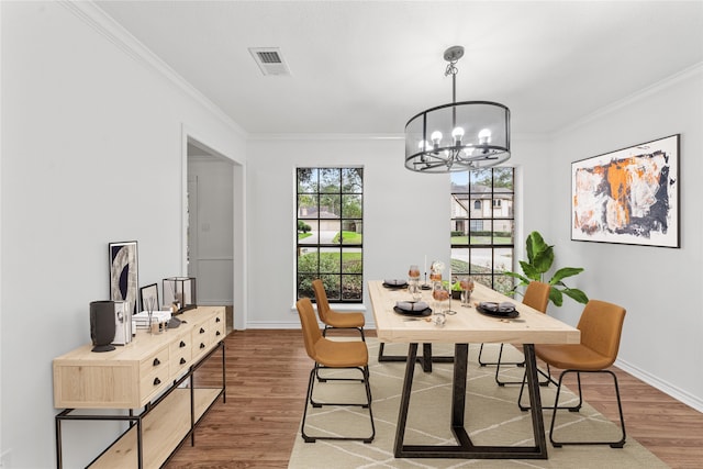 dining space featuring crown molding, dark wood-type flooring, and a notable chandelier