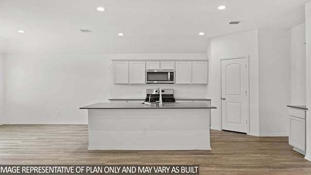 kitchen with sink, appliances with stainless steel finishes, a kitchen island with sink, and light wood-type flooring