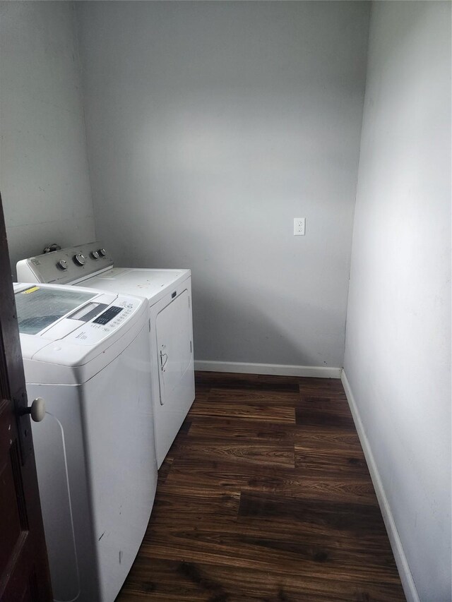 washroom featuring washing machine and dryer, laundry area, dark wood finished floors, and baseboards
