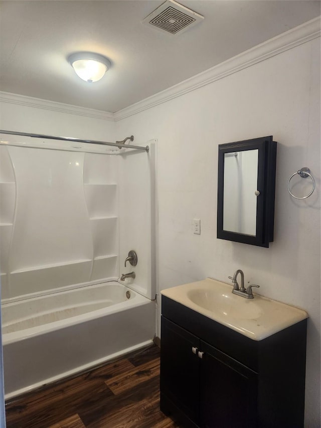 bathroom with shower / tub combination, wood finished floors, vanity, visible vents, and crown molding