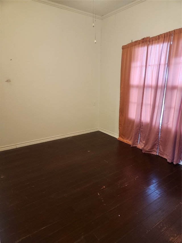 spare room featuring baseboards, dark wood-style flooring, and ornamental molding
