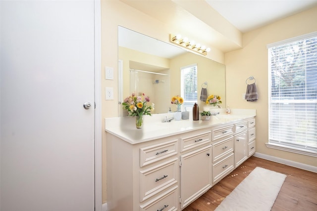 bathroom featuring hardwood / wood-style flooring, vanity, and walk in shower