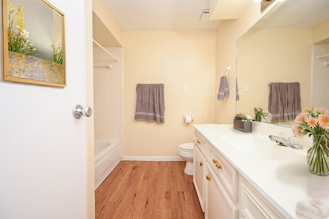 full bathroom with hardwood / wood-style floors, toilet, vanity, and washtub / shower combination