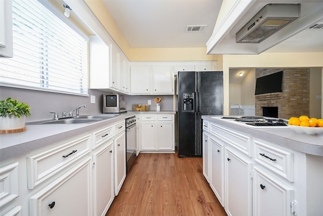 kitchen with light hardwood / wood-style flooring, sink, black refrigerator with ice dispenser, white cabinetry, and custom range hood