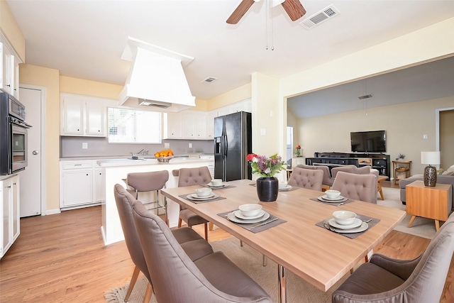 dining area with light hardwood / wood-style flooring and ceiling fan