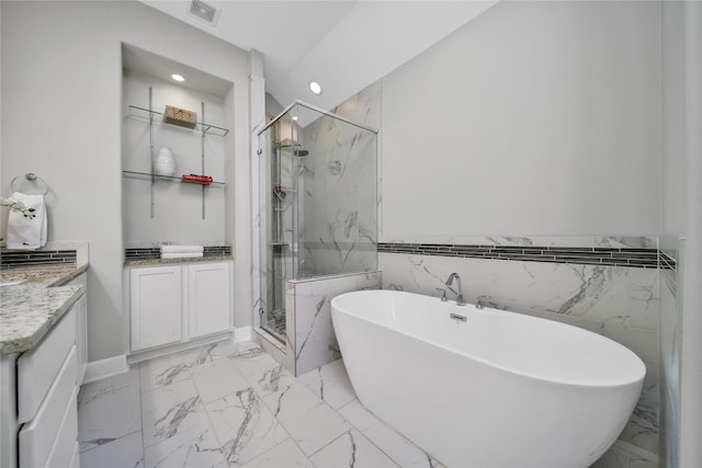 full bath featuring marble finish floor, a freestanding tub, vanity, and a marble finish shower