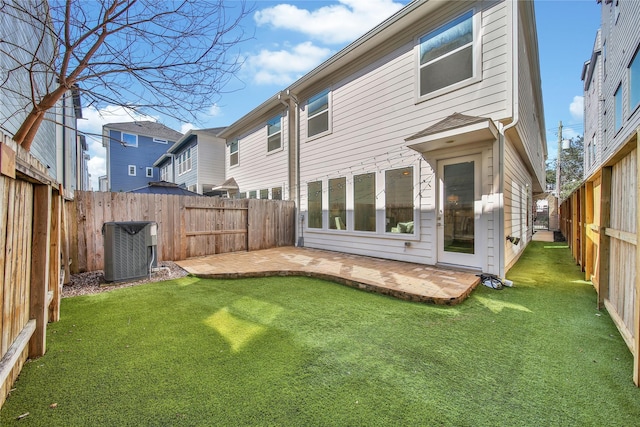 back of house with a yard, a fenced backyard, cooling unit, and a patio