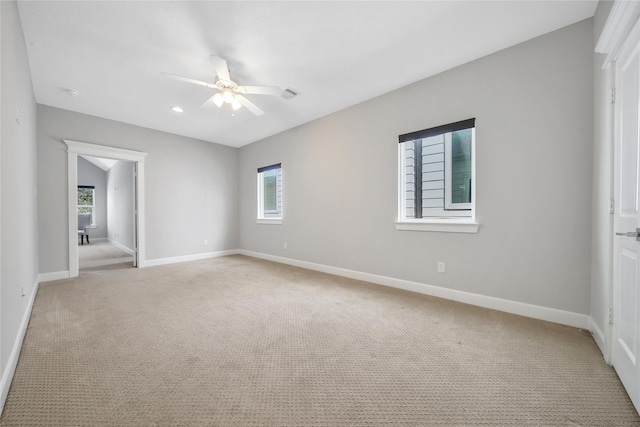 unfurnished room with light colored carpet, visible vents, and baseboards