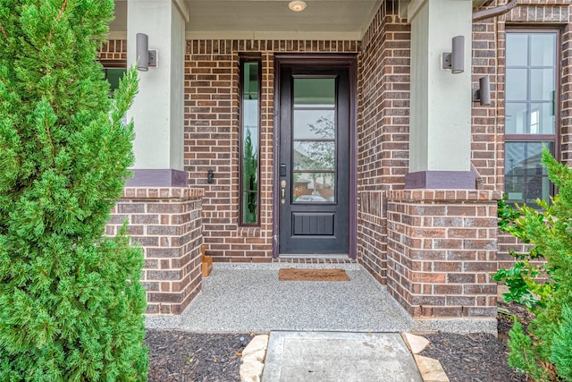 entrance to property featuring brick siding