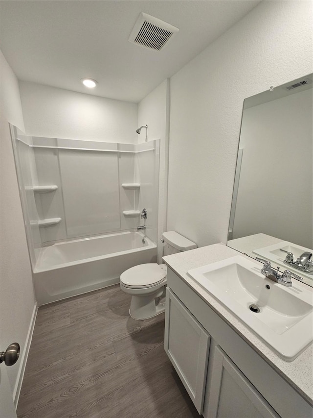 full bathroom with hardwood / wood-style flooring, vanity, toilet, and washtub / shower combination