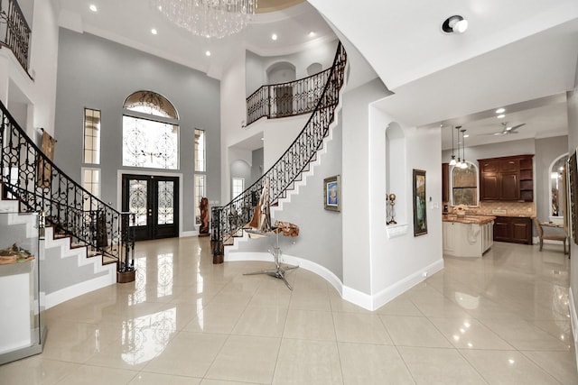 entryway with a high ceiling, french doors, and light tile patterned floors