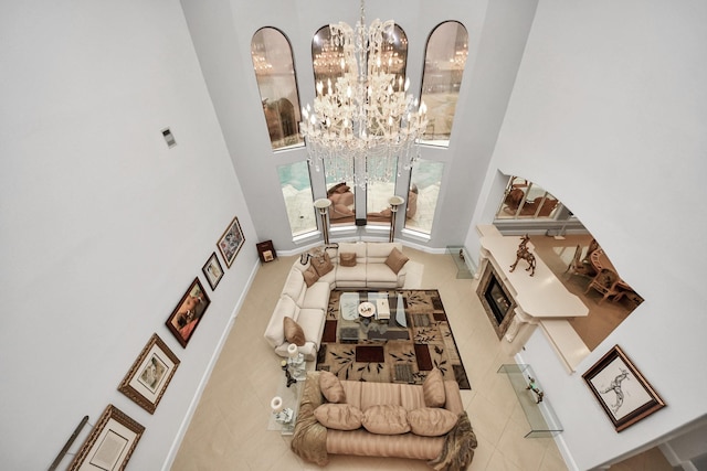 living room with a high ceiling, light tile patterned flooring, and a notable chandelier