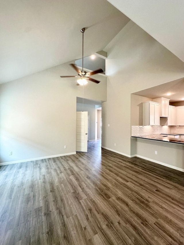 unfurnished living room with dark hardwood / wood-style flooring, ceiling fan, and high vaulted ceiling