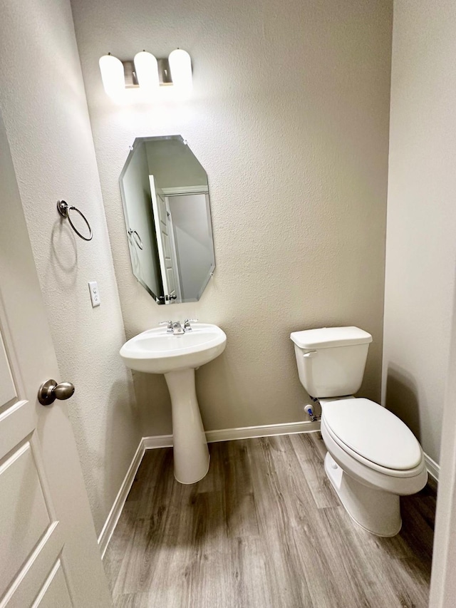 bathroom with sink, toilet, and hardwood / wood-style floors