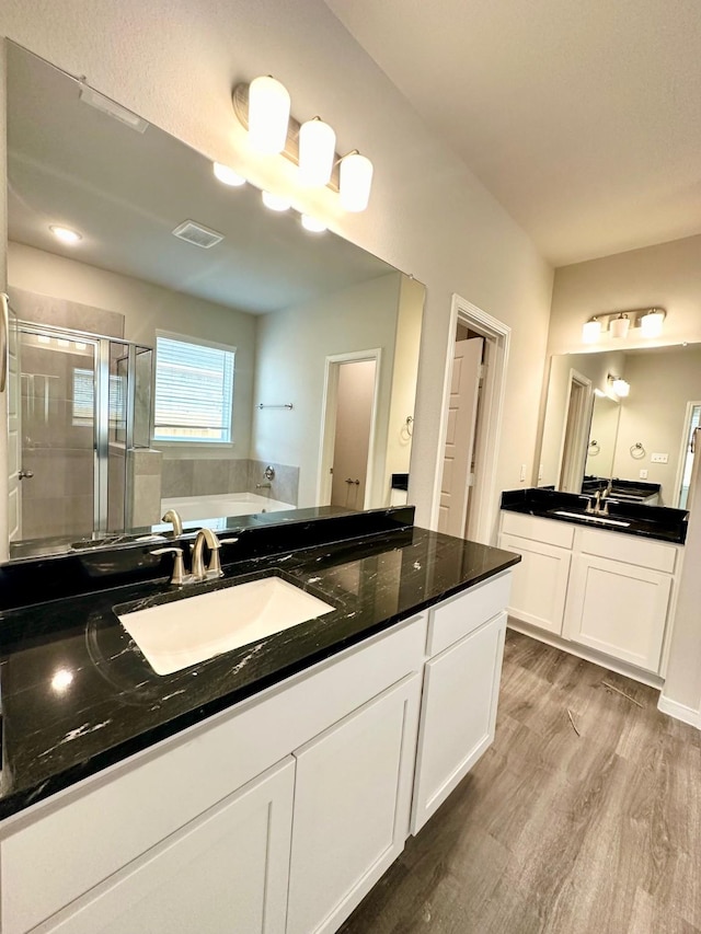 bathroom with separate shower and tub, vanity, and hardwood / wood-style floors