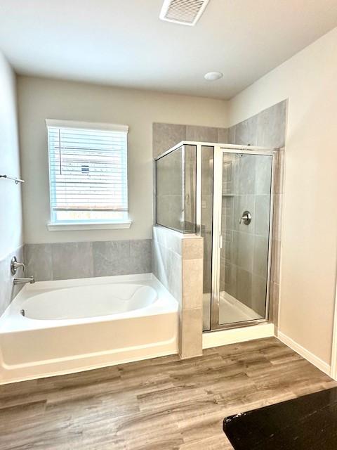 bathroom featuring shower with separate bathtub and hardwood / wood-style floors