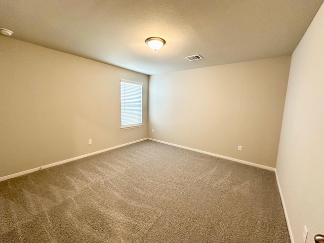 carpeted empty room featuring a textured ceiling