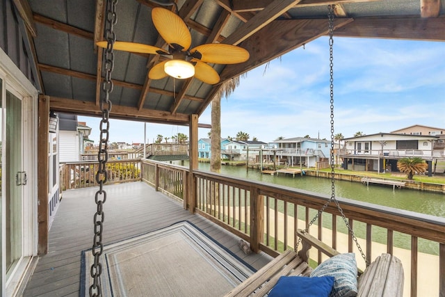 deck featuring a ceiling fan, a residential view, and a water view