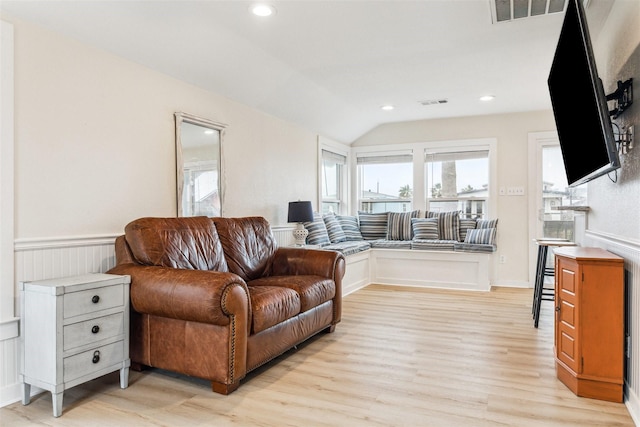 living room featuring lofted ceiling, visible vents, light wood-style flooring, and recessed lighting