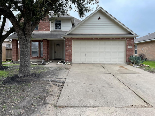 traditional-style home with a garage, concrete driveway, and brick siding