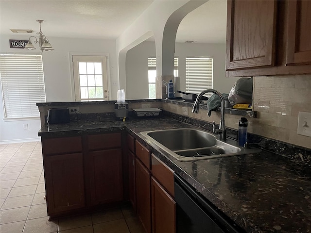 kitchen with arched walkways, a peninsula, a sink, backsplash, and dishwasher