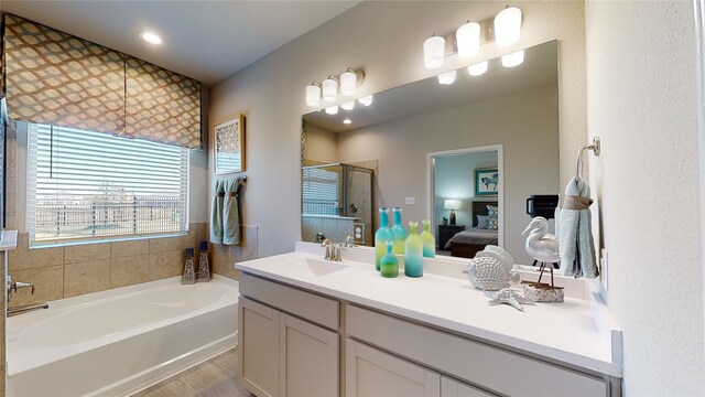 26356 Cooperstown Way, Splendora, TX 77372 - bathroom with wood finished floors, ensuite bath, a shower stall, a bath, and vanity