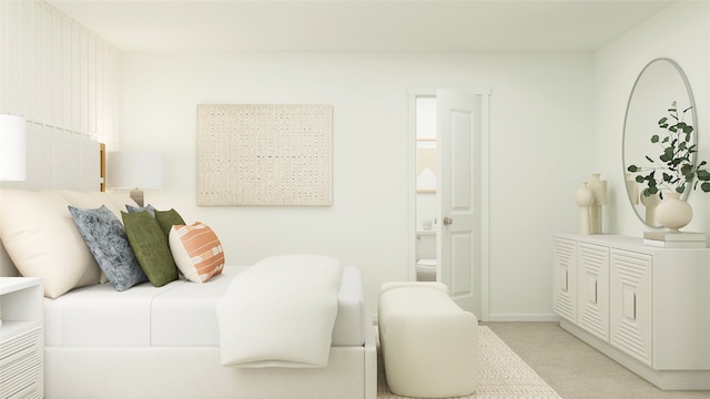 bedroom with light carpet, baseboards, and ensuite bath
