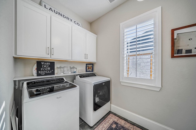 washroom with washing machine and dryer, cabinet space, and baseboards