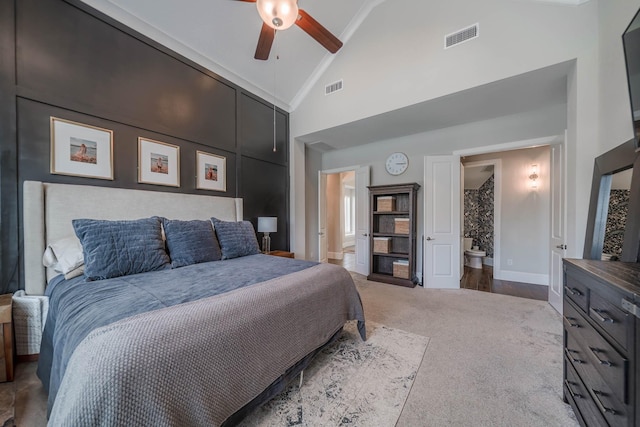 carpeted bedroom with ensuite bathroom, high vaulted ceiling, visible vents, and baseboards