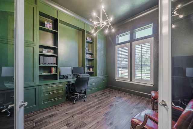 office space featuring dark wood-style floors, built in shelves, crown molding, a chandelier, and baseboards