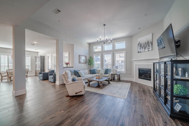 living area featuring a healthy amount of sunlight, a fireplace, visible vents, and dark wood-type flooring