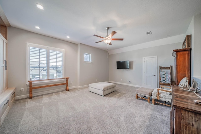 sitting room with baseboards, visible vents, and light colored carpet