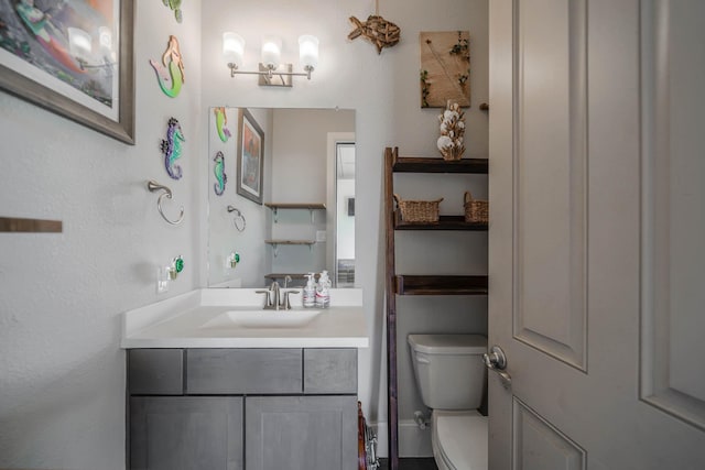 half bathroom with vanity and toilet