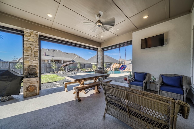 view of patio featuring outdoor dining area, area for grilling, an outdoor hangout area, a ceiling fan, and fence