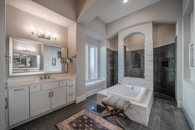 full bath featuring baseboards, a jetted tub, vanity, and a walk in shower