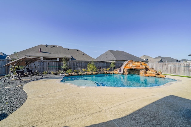 view of pool with a water slide, a patio area, a fenced backyard, and a fenced in pool