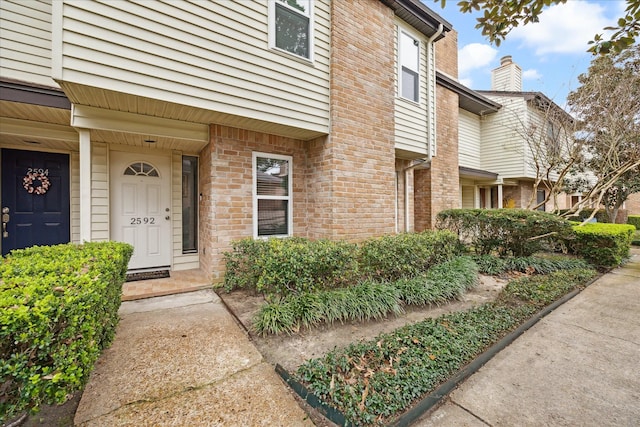 entrance to property featuring brick siding