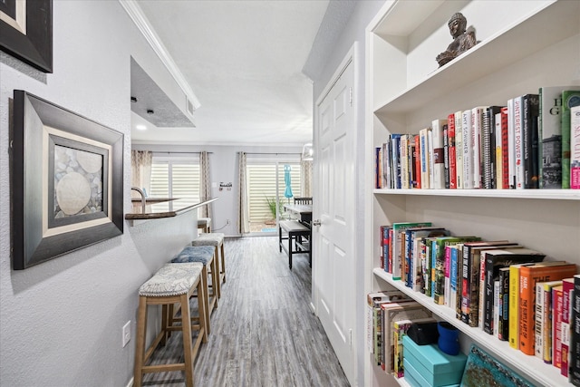 hall featuring wood finished floors and crown molding