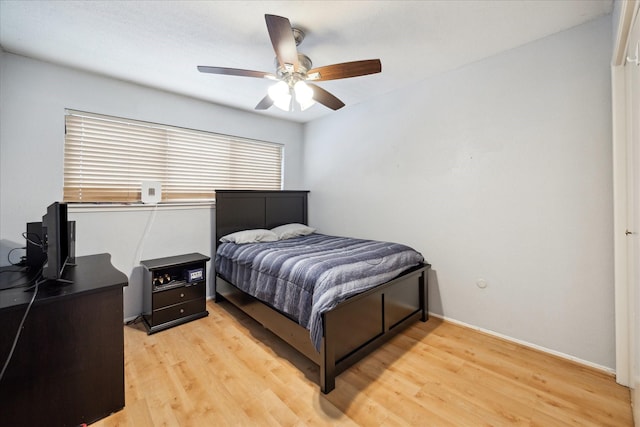 bedroom featuring ceiling fan, light wood-type flooring, and baseboards