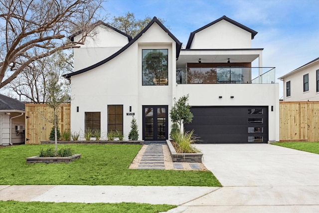 view of front of property featuring a garage, french doors, a balcony, and a front lawn