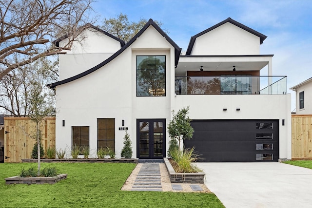 view of front of property with french doors, a front yard, a garage, and a balcony