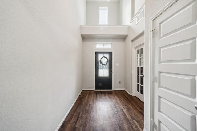 foyer entrance with dark wood-type flooring and a high ceiling