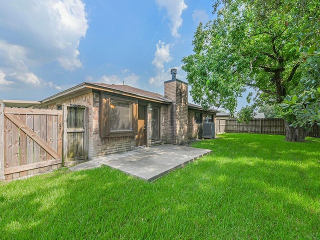 rear view of property with central AC unit, a lawn, and a patio area